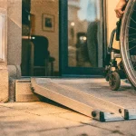 Rampe fauteuil roulant PMR amovible antidérapante devant une entrée